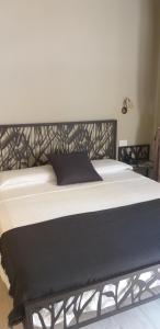 a bed with a black headboard and white sheets at Casa D'amore in Riomaggiore