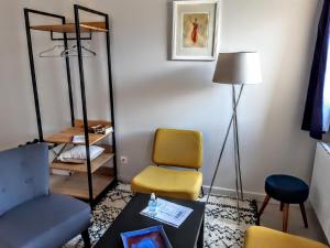 a living room with a chair and a mirror at 10 Côté Cour in Chaux