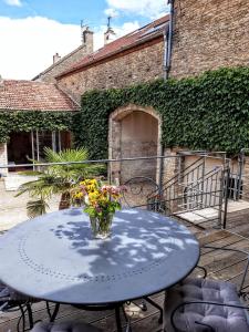 a blue table with a vase of flowers on a patio at 10 Côté Cour in Chaux