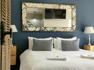 um quarto com um grande espelho por cima de uma cama em Excellent Guest House em Bellville