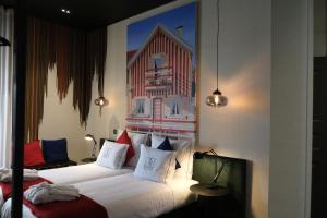 1 dormitorio con 2 camas y una pintura de un edificio en 34 GuestHouse, en Setúbal