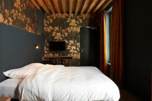a bed in a room with a white bedspread at Nonam Boutique Hotel in Ghent