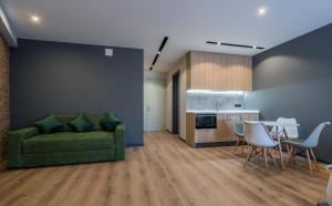a living room with a green couch and a kitchen at Gudauri, Atrium Suites in Gudauri