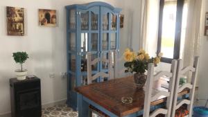 ein Esszimmer mit einem Tisch und einem blauen Schrank in der Unterkunft Casa Mena in Nerja