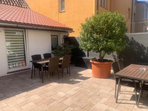a patio with a table and chairs and a tree at Apartamenty Kris in Mikołajki