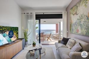 sala de estar con sofá y vistas al océano en T3- Infini bleu 4 étoiles - 63 m2 - vue océan - St-Gilles en Saint-Gilles-les-Bains