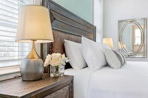 a bedroom with a bed with a lamp and white pillows at Stunning 4BR-5BR near Frnch Quarter Homes by Hosteeva in New Orleans
