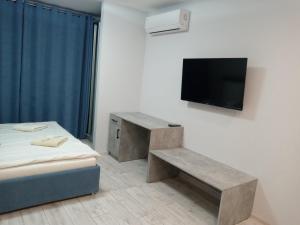 a room with a bed and a tv and a bench at Квартира в центре на Другетов in Uzhhorod