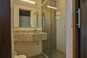 a bathroom with a sink and a glass shower at Vila Dom Bosco in Campos do Jordão +39 photos