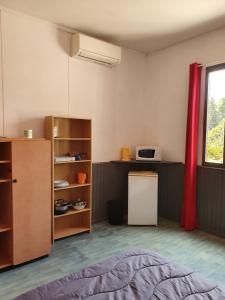Zimmer mit einem Bett, einem Kühlschrank und einem Fenster in der Unterkunft Camping des 2 Rives- Chambres in Étang-sur-Arroux