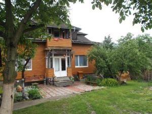 a wooden house with a porch and a yard at Rukavychka in Yaremche