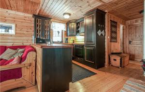 a kitchen and living room in a log cabin at Gorgeous Home In stby With Wifi in Østby