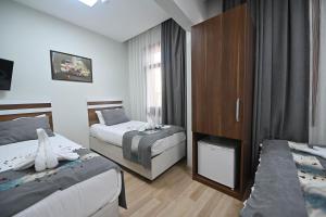 a hotel room with two beds and a cabinet at Safir Gold Hotel in Istanbul