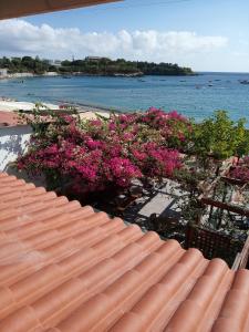 a view of the beach with pink flowers on a roof at Buganvilla Sea View apts in Agia Pelagia