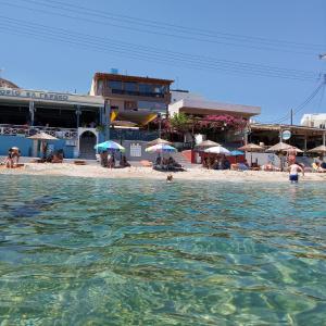 a group of people in the water in front of a beach at Buganvilla Sea View apts in Agia Pelagia