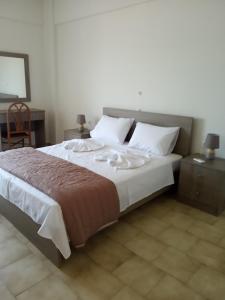 a bedroom with a large bed with white pillows at Buganvilla Sea View apts in Agia Pelagia