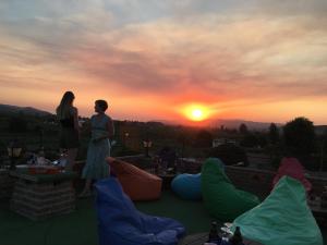 dos personas de pie en un techo viendo la puesta de sol en Rebetika Hotel & bistro, en Selçuk