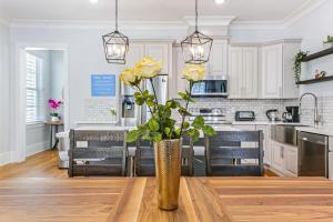 a kitchen with a table with yellow roses in a vase at Stunning 4BR-5BR near French Quarter Homes by Hosteeva in New Orleans +282 photos