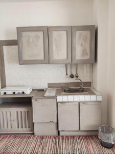 a kitchen with white cabinets and a sink at il Faro di Zancle, la Porta della Sicilia in Messina