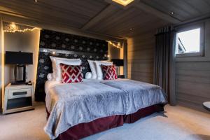 a bedroom with a large bed with red and white pillows at Hotel Le K2 Altitude in Courchevel