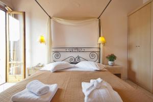 a bedroom with a bed with two towels on it at Acropole Delphi City Hotel in Delphi