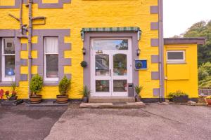 a blue and white building with a yellow door at Argyll House in Oban