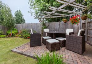 a patio with a table and chairs under a pergola at Woodlea House with Hot tub in York