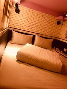 ein Schlafzimmer mit einem großen Bett mit weißer Bettwäsche und Kissen in der Unterkunft Kenting My Home in Kenting