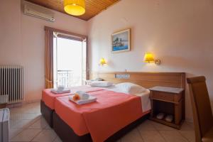 a hotel room with a bed with a red blanket at Acropole Delphi City Hotel in Delphi