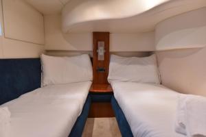 two beds in a small room with a table at Sailing 360 Night On Board Experience in Vila Nova de Gaia