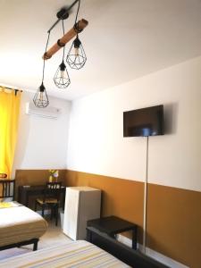 a room with a bed and a tv on the wall at The Yellow House in Fiumicino