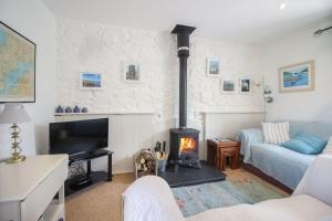 PerranwellにあるRoseland Cottageのリビングルーム(暖炉、ソファ付)