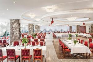 a banquet hall with white tables and red chairs at Park Hotel Moskva in Sofia