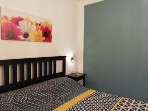 1 dormitorio con 1 cama y una pintura en la pared en The Yellow House, en Fiumicino