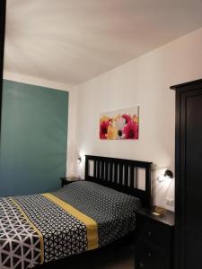 1 dormitorio con 1 cama y una pintura en la pared en The Yellow House, en Fiumicino