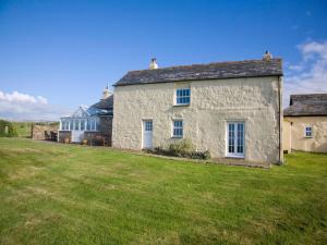 a white stone house with a large yard at Higher Tresmorn Farm in Crackington Haven