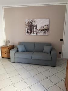 eine Couch in einem Wohnzimmer mit einem Gemälde an der Wand in der Unterkunft FUORI PORTA NUOVA in Sarzana