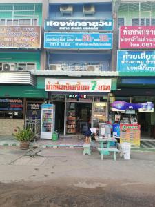 a person sitting at a table in front of a store at กอล์ฟ​&กิ๊ฟ​โฮม in Phitsanulok