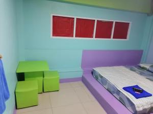 a room with a bed and two chairs in it at กอล์ฟ​&กิ๊ฟ​โฮม in Phitsanulok