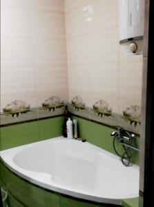a bathroom with a white tub and a sink at Здається подобово 3кімнатна квартира з wifi i екслюзивним ремонтом,є кімната гардероб,спальня і кімната,санвузол і ванна також парковочне місце in Chernivtsi