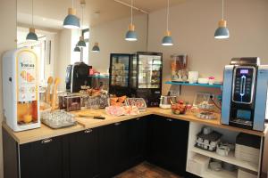 a kitchen with a counter top with a refrigerator at Hôtel La Couronne in Marmande
