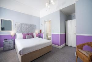 a purple and white bedroom with a bed and a chair at The Mariners - Torquay in Torquay