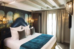 a bedroom with a bed with a blue and white comforter at Hôtel Da Vinci & Spa in Paris