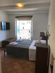 - une chambre avec un grand lit et une fenêtre dans l'établissement Candidina 2, à Vernazza