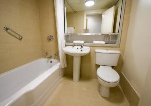 a bathroom with a sink, toilet and bathtub at Blooms Hotel in Dublin