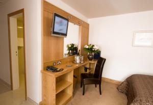 een slaapkamer met een bureau, een bed en een televisie bij Blooms Hotel in Dublin