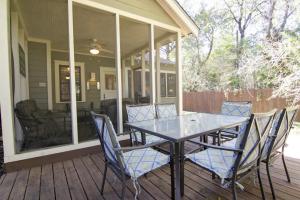 - une table à manger et des chaises sur une terrasse couverte avec moustiquaire dans l'établissement Keasbey Cottage, à Austin