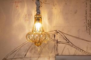 a chandelier hanging from a wall with a drawing at Hôtel Da Vinci & Spa in Paris