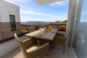 a table and chairs on a balcony with a view at Apartments Vladimir #3 in Makarska