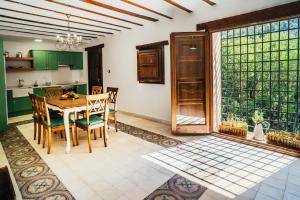 a kitchen with green cabinets and a table and chairs at La Casa del Boticario in Alcalá del Júcar